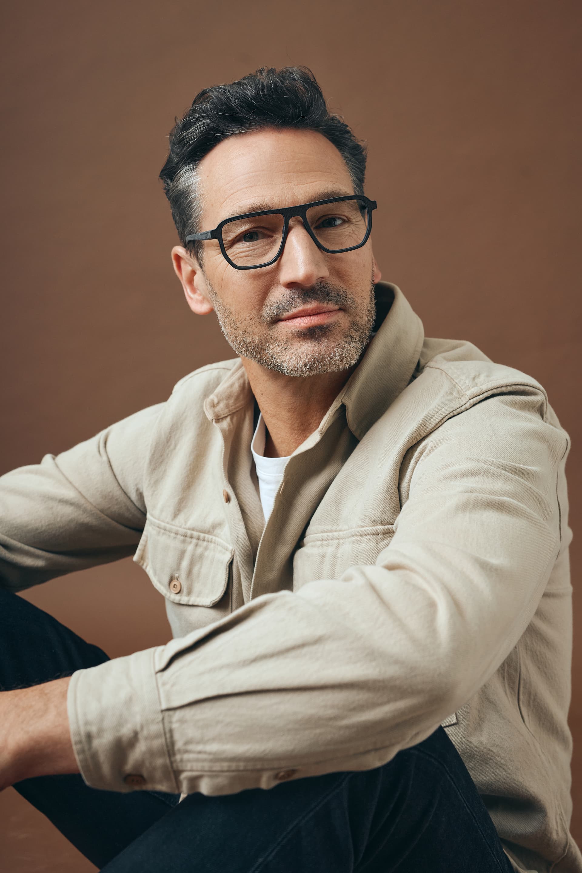 Frau mit mantel und sonnenbrille mit trapezfoermigen glaesern im havanah stil