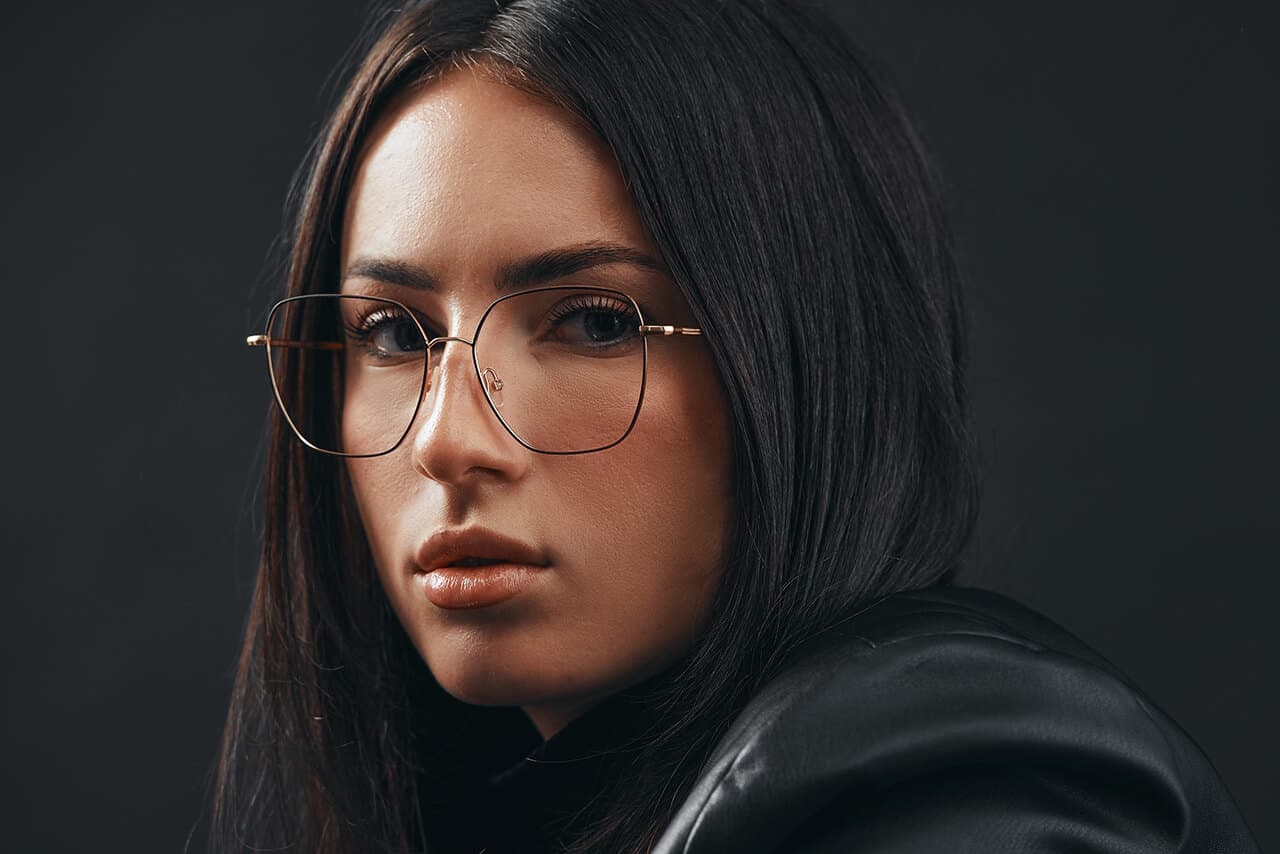 Frau mit schwarzer breiter oversized sonnenbrille steht im fahrstuhl